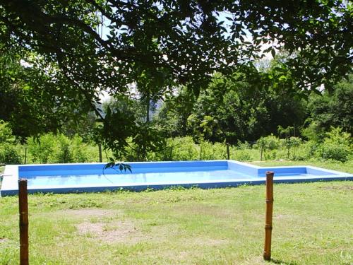 a large blue swimming pool in a field at Cabañas Mayma in Vaqueros