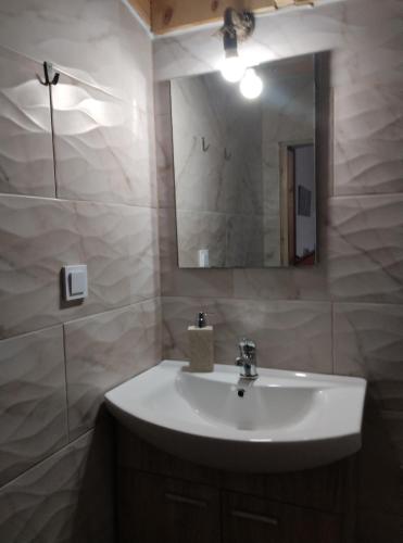 a bathroom with a white sink and a mirror at Villa Απέραντο Γαλάζιο in Samothraki