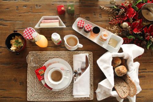 einen Holztisch mit einem Frühstück mit Kaffee und Brot in der Unterkunft Casa Garay Hotel 658 in Asunción