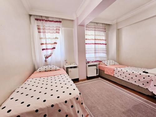 two beds in a small room with two windows at Clover House 2 in Istanbul