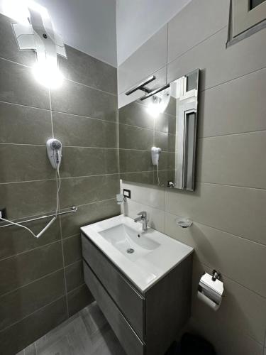 ein Bad mit einem Waschbecken und einem Spiegel in der Unterkunft Alloggio Pulcinella 2 Affittacamere in Acerra