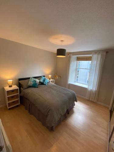 a bedroom with a large bed and a window at Lombard Hide Away in Inverness