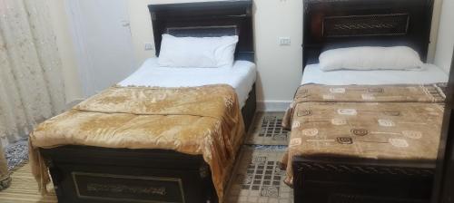 duas camas num pequeno quarto com saias em Adam Pyramids no Cairo