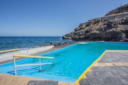 a swimming pool with the ocean in the background at Casa el Mar apartamento Pescador in Lomo de Mena
