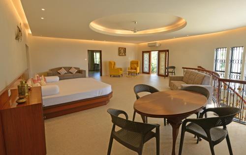 迪布魯加爾的住宿－Manohari The Tea Retreat，卧室配有一张床和一张桌子及椅子