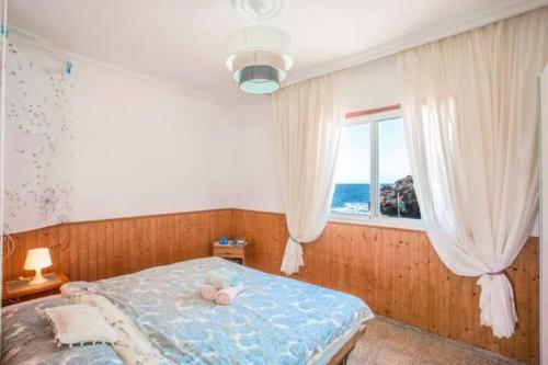 a bedroom with a bed with a stuffed animal on it at Casa el Mar apartamento Pescador in Lomo de Mena