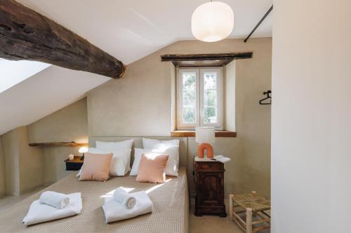 ein Schlafzimmer mit einem Bett mit weißen Kissen und einem Fenster in der Unterkunft A Macina in Porri