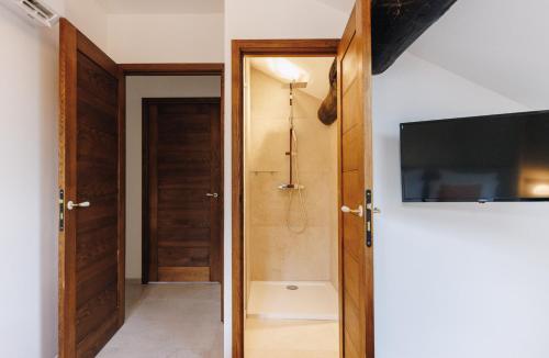 uma casa de banho com um chuveiro e uma televisão na parede em A Macina em Porri