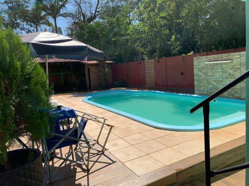 a swimming pool with a table and an umbrella at Apart JM in Puerto Iguazú