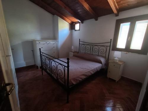 een slaapkamer met een zwart bed en een raam bij Casa Villaggio Moresco basso in Peschici