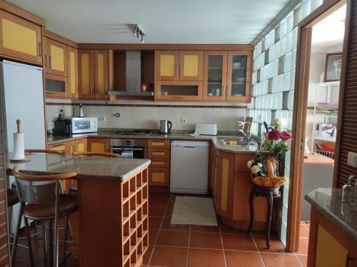 a kitchen with wooden cabinets and a counter top at Encosta do Pinhão in Casal de Loivos