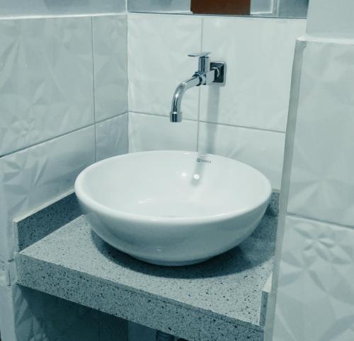 - un lavabo blanc assis sur un comptoir dans la salle de bains dans l'établissement HOTEL LA BELLA Y EL LEON, à Huánuco