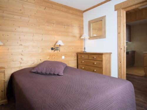 une chambre avec un lit et un mur en bois dans l'établissement 2 pièces luxe avec balcon et Wifi à 500m des pistes - FR-1-449-44, à Tignes