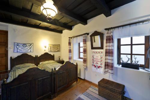 a bedroom with a large wooden bed and a window at Hollóköves Vendégházak in Hollókő