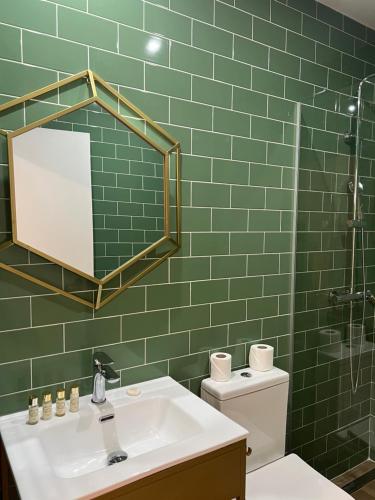 a green tiled bathroom with a sink and a mirror at 145 Townhouse in Ílhavo
