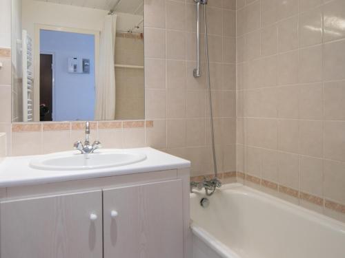 une salle de bain avec un lavabo et une baignoire dans l'établissement T2 avec balcon sud/ouest à 500 m des pistes - FR-1-449-137, à Tignes
