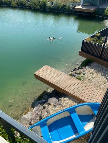 a blue boat sitting next to a wooden table in the water at Pri jazere - Golf rezort in Hrubá Borša