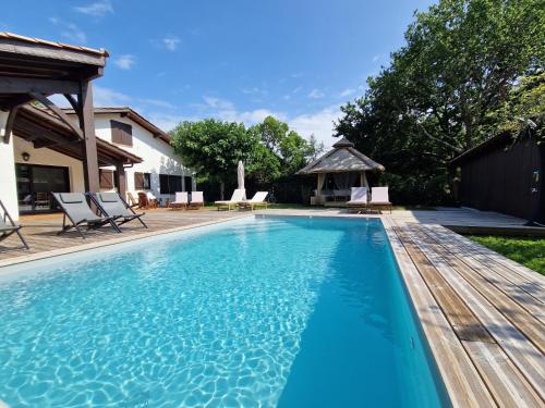 - une piscine bleue avec un kiosque dans l'établissement Villa 12 personnes Avec piscine et vélos Proche océan, à Moliets-et-Maa