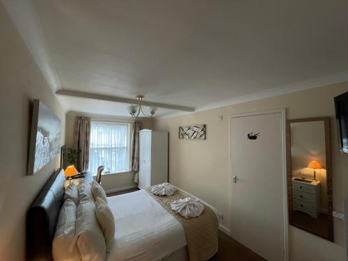 a bedroom with a bed with a couch and a window at The Southbourne Villa in Torquay