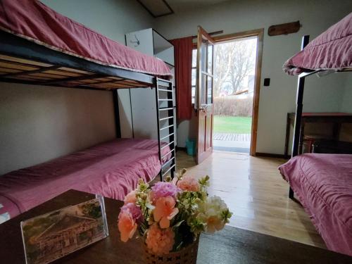 a room with two bunk beds and a table with flowers at House 1903 in Ushuaia