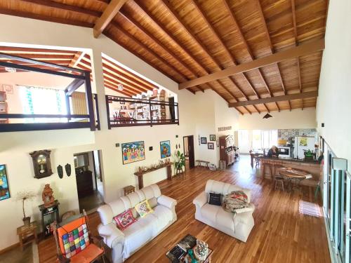 a living room with white furniture and a wooden ceiling at Morada do Ipê Pousada in Chapada dos Guimarães