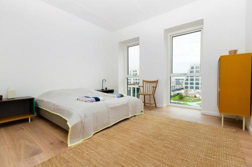 Dormitorio blanco con cama y ventana grande en Udsigt til 20.000.000 DKK - m.plads til 6 personer, en Copenhague