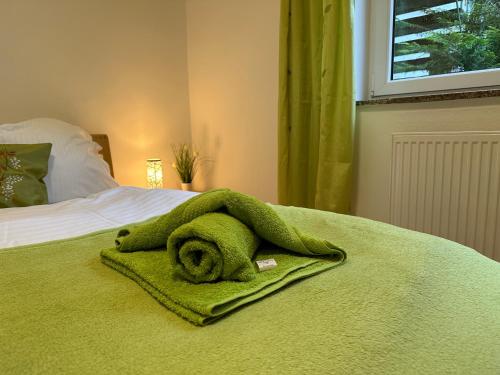 a green towel on top of a bed at Pöstlingbergoase in Linz