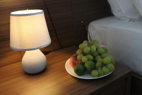 a plate of fruit on a table next to a lamp at Maison de Cheeramie - Tourist Apartments Tra Mare e Etna in Mascali
