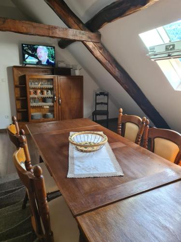 a dining room with a wooden table and a tv at Glaciar Guest House in Manteigas