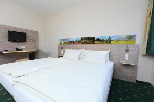 מיטה או מיטות בחדר ב-Jeddinger Hof Land- und Seminarhotel