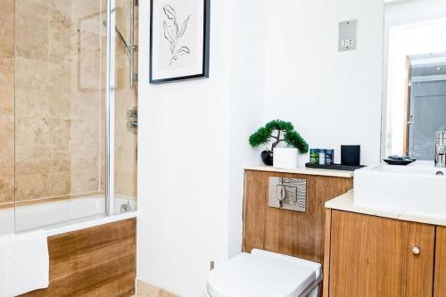 a bathroom with a toilet and a sink and a shower at Hidden Gem with En-Suites in West Hampstead in London