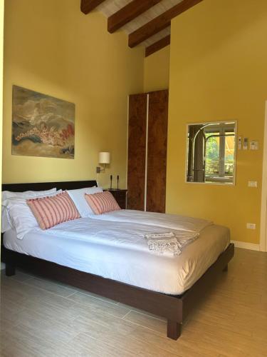 una camera da letto con un grande letto con lenzuola bianche e cuscini rossi di Agriturismo Al Robale ad Almenno San Bartolomeo
