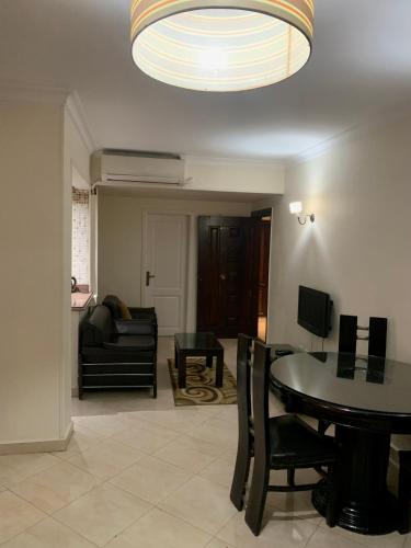 een woonkamer met een tafel en een bank bij Airport hostel room for transit in Caïro