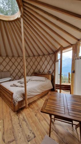 1 dormitorio en una yurta con cama y mesa en MonvisoRelax en Ostana