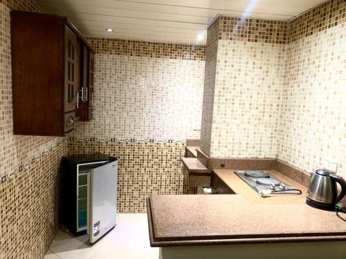a small kitchen with a counter and a refrigerator at Airport hostel room for transit in Cairo