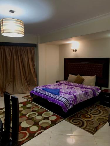 a bedroom with a purple bed and a rug at Airport hostel room for transit in Cairo
