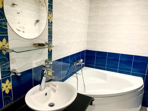 een blauwe en witte badkamer met een wastafel en een bad bij Airport hostel room for transit in Caïro