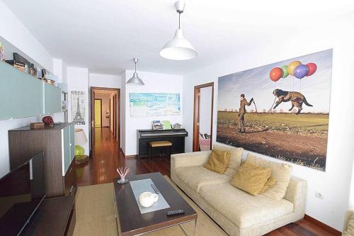 una sala de estar con sofá y una pintura de un camello en JUST-ROOM. Apartamento Angelica en Camargo