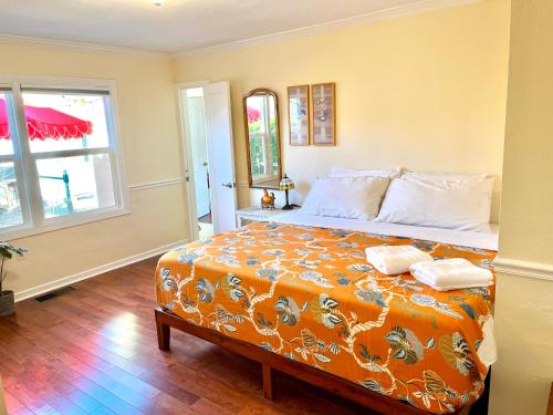 een slaapkamer met een groot bed en een oranje deken bij Spacious Renovated Petaluma Home- Pool Table, Fire Pit, Parking in Petaluma