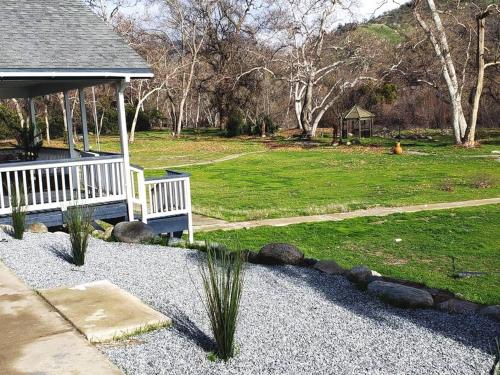 a garden with a white bench and a grass field at Oasis Riverfront House -10 min to Sequoia in Three Rivers