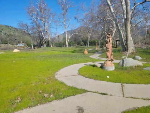 a statue of a woman on a path in a park at Oasis Riverfront House -10 min to Sequoia in Three Rivers