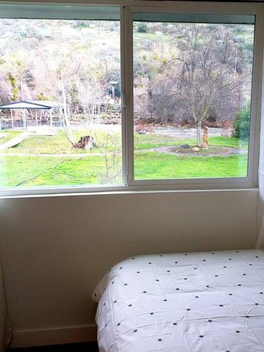 a bedroom with a window with a bed in front of it at Oasis Riverfront House -10 min to Sequoia in Three Rivers