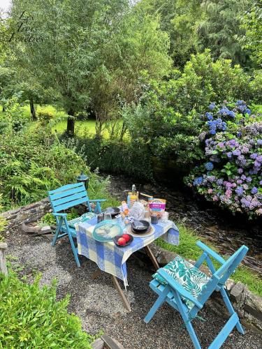 a picnic table and two chairs in a garden at Les Trois Fenêtres in Beauficel
