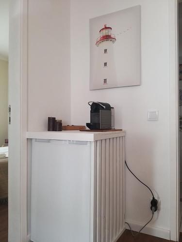 a white wall with a counter with a phone on it at Casas dos Seixos in Moledo