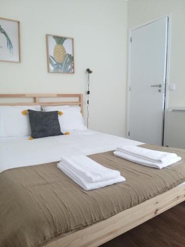 a bed with two white towels on top of it at Casas dos Seixos in Moledo