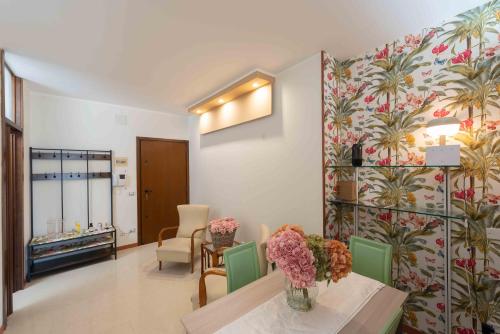 una habitación con una mesa con flores en la pared en URBAN LIFE FLAT, en Verona