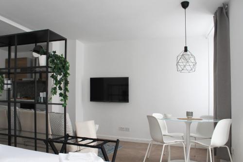a white dining room with a table and chairs at Appartamento Tiffany in Brescia