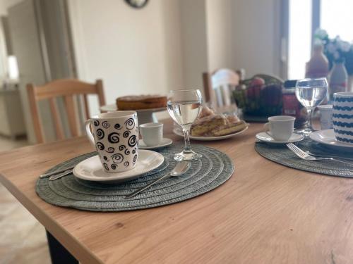 a wooden table with plates of food and wine glasses at Maison de Cheeramie - Tourist Apartments Tra Mare e Etna in Mascali