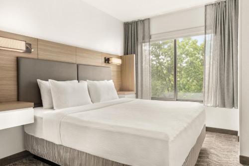 um quarto com uma grande cama branca e uma janela em SpringHill Suites Boston Andover em Andover