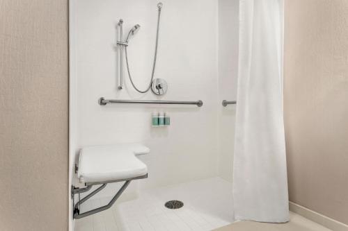 a bathroom with a shower with a white shower curtain at SpringHill Suites Boston Andover in Andover